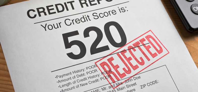 Credit report with a credit score of 520 in big print and the word Rejected stamped across it in red.