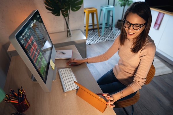 Person investing on computer and smiling.