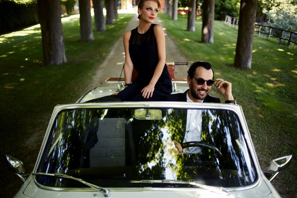 Two seemingly wealthy people in a fancy car.