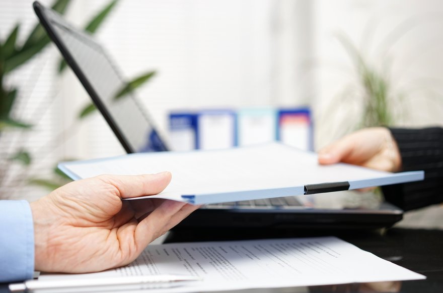 Person handing over a document.